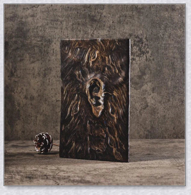 Aged Necronomicon prop with demonic face cover, perfect for dark fantasy decor