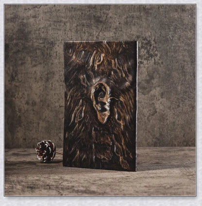Aged Necronomicon prop with demonic face cover, perfect for dark fantasy decor