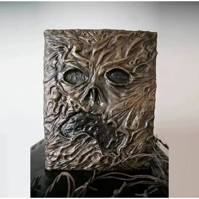 Aged Necronomicon prop with demonic face cover, perfect for dark fantasy decor