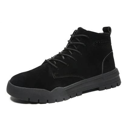 A pair of black, suede British-style Martin boots with a thick, rubber sole and round toe shape.