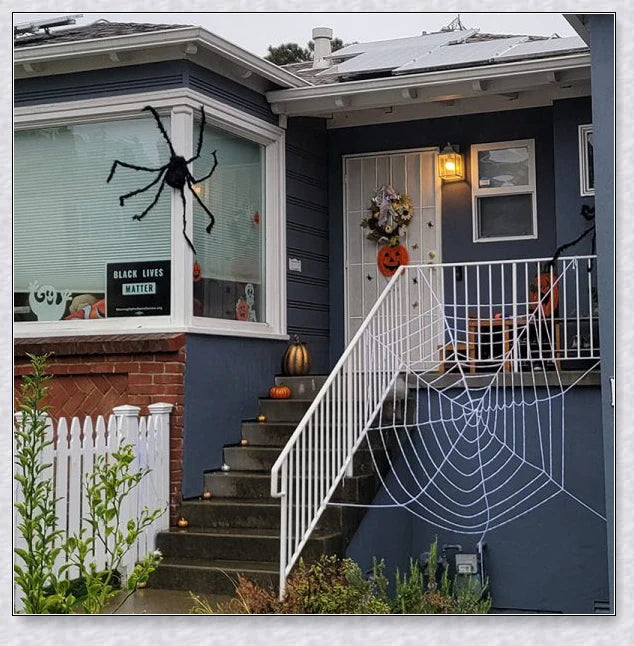 Massive black and white Halloween spider web decoration that stretches across large areas, creating a haunting atmosphere