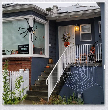 Massive black and white Halloween spider web decoration that stretches across large areas, creating a haunting atmosphere