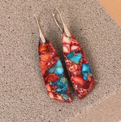 Geometric flower shape pendant earrings in copper with gold hooks, available in red, green, and blue.