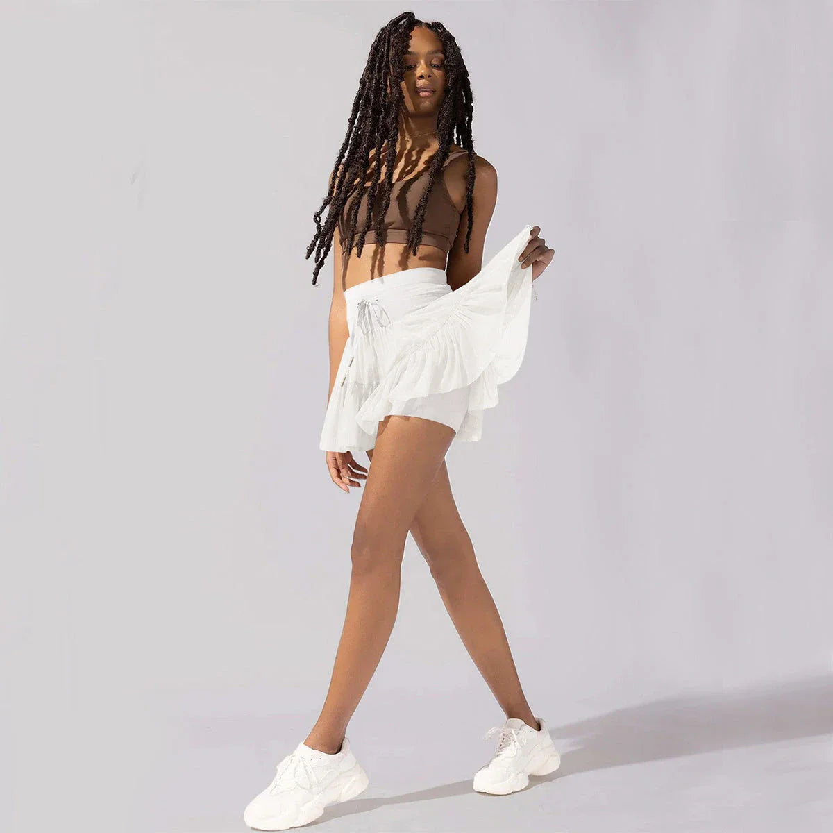 A stylish high-waist lace-up sports skirt with built-in safety shorts in a variety of vibrant colors.