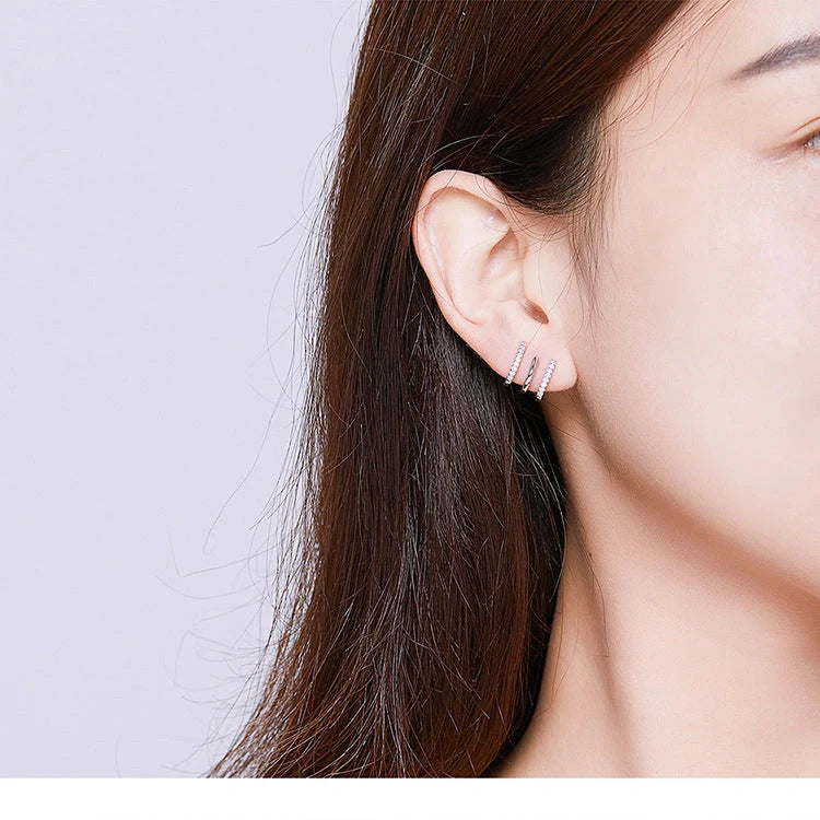 Elegant three-layer sterling silver heart earrings with sparkling gems, perfect for any occasion.