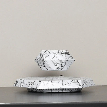 Levitating marble bonsai pot floating above magnetic base