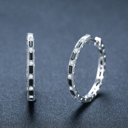 A pair of elegant black zircon earrings with a round, geometric design made of premium copper