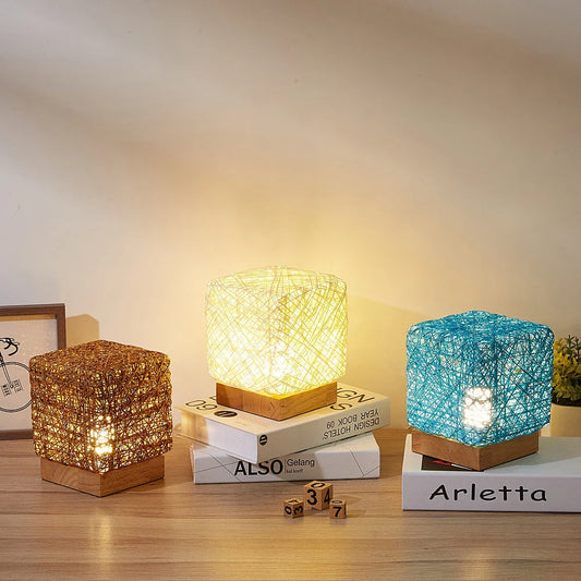 Handcrafted dimmable LED desk lamp made from sustainable rattan and wood, providing adjustable lighting and USB charging for home or office use.