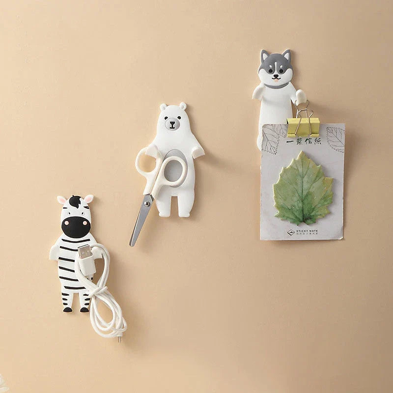 Assorted animal-shaped wall hooks in various colours, including bear, zebra, and cow designs, displayed on a white background