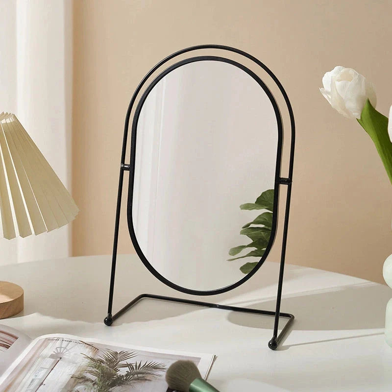 A large, minimalist desktop makeup mirror with a sleek black frame and a spacious viewing area for detailed grooming and makeup application.