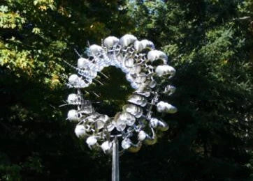 Elegant revolving metal windmill outdoor ornament with dual-layered blades creating a mesmerizing display in the garden