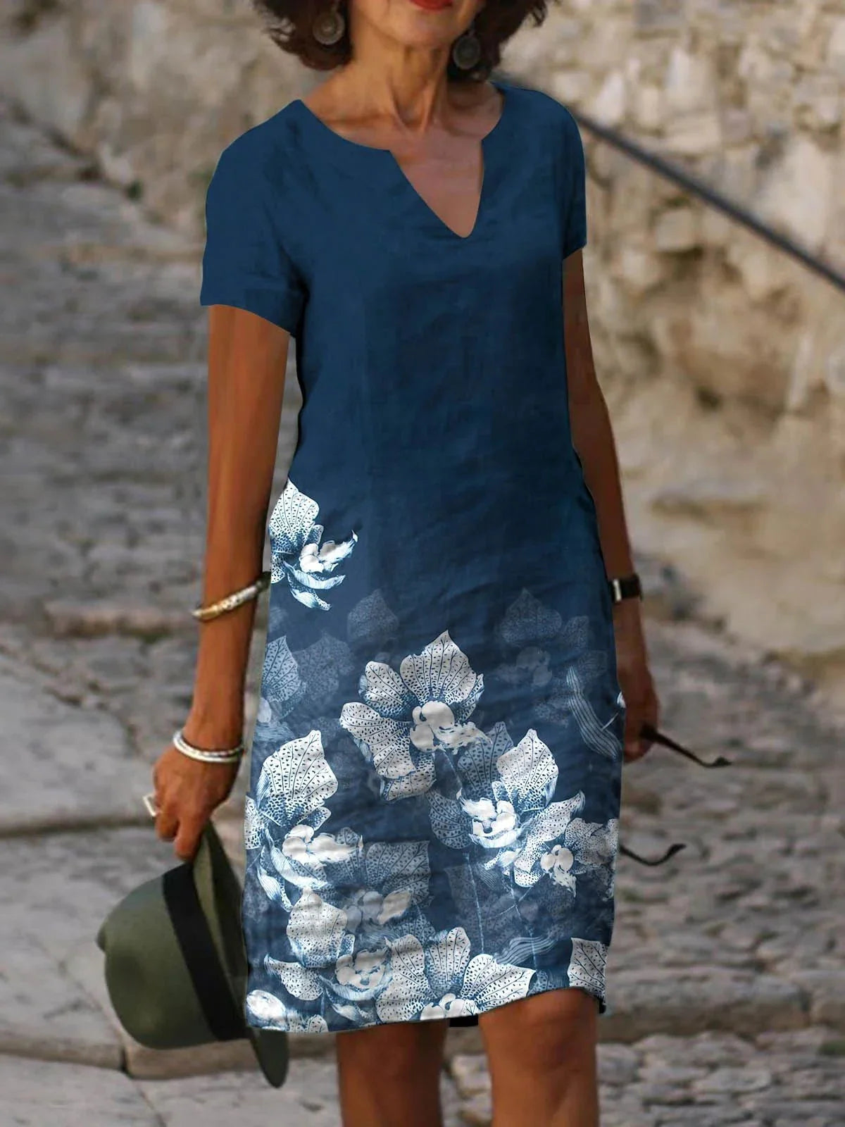 A floral printed midi dress made from a cotton-linen blend fabric, featuring a V-neck and short sleeves.