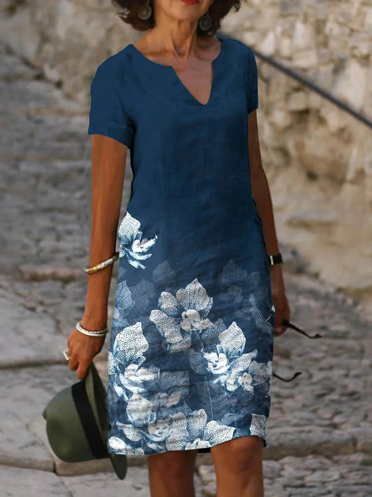 A floral printed midi dress made from a cotton-linen blend fabric, featuring a V-neck and short sleeves.