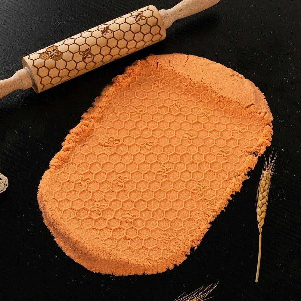 Embossed rolling pin made of natural wood with intricate designs for creating textured baked goods