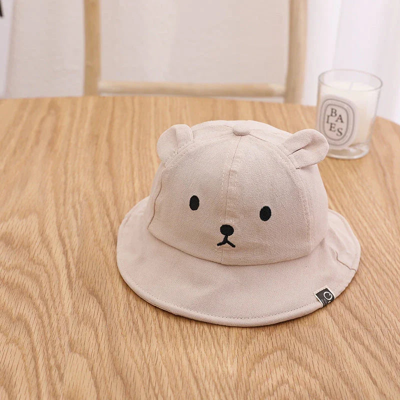 A cosy baby sun hat with cute bear ears, made from soft cotton and polyester for breathability and comfort