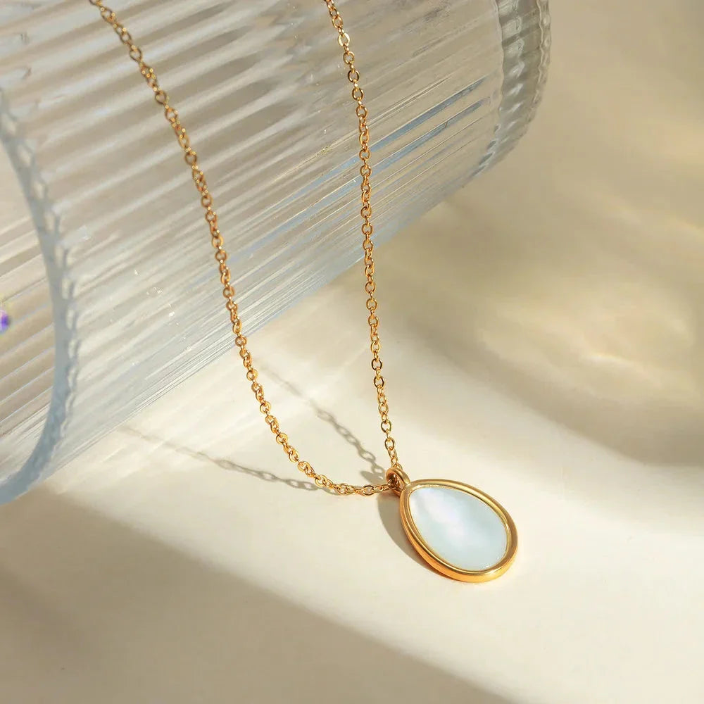 A luxury opal inlaid stainless steel drop pendant necklace with a 18K gold plating, showcasing a captivating and sophisticated design.