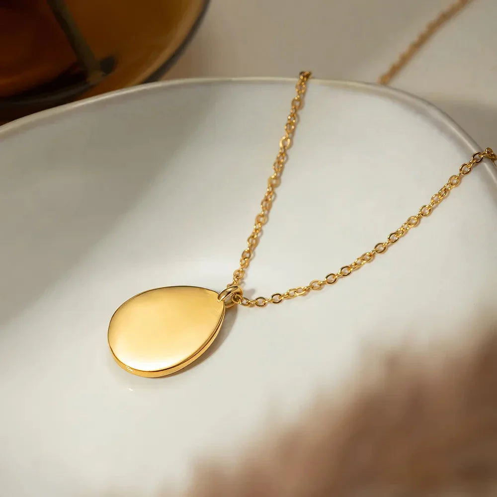 A luxury opal inlaid stainless steel drop pendant necklace with a 18K gold plating, showcasing a captivating and sophisticated design.