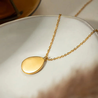 A luxury opal inlaid stainless steel drop pendant necklace with a 18K gold plating, showcasing a captivating and sophisticated design.