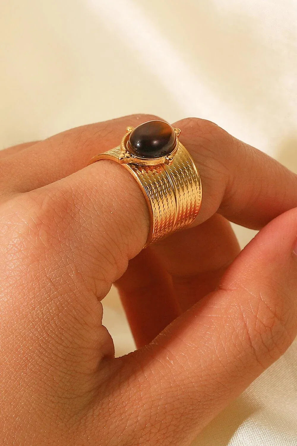 A close-up view of a polished 18K gold-plated wide-open ring, showcasing its unique and eye-catching design.