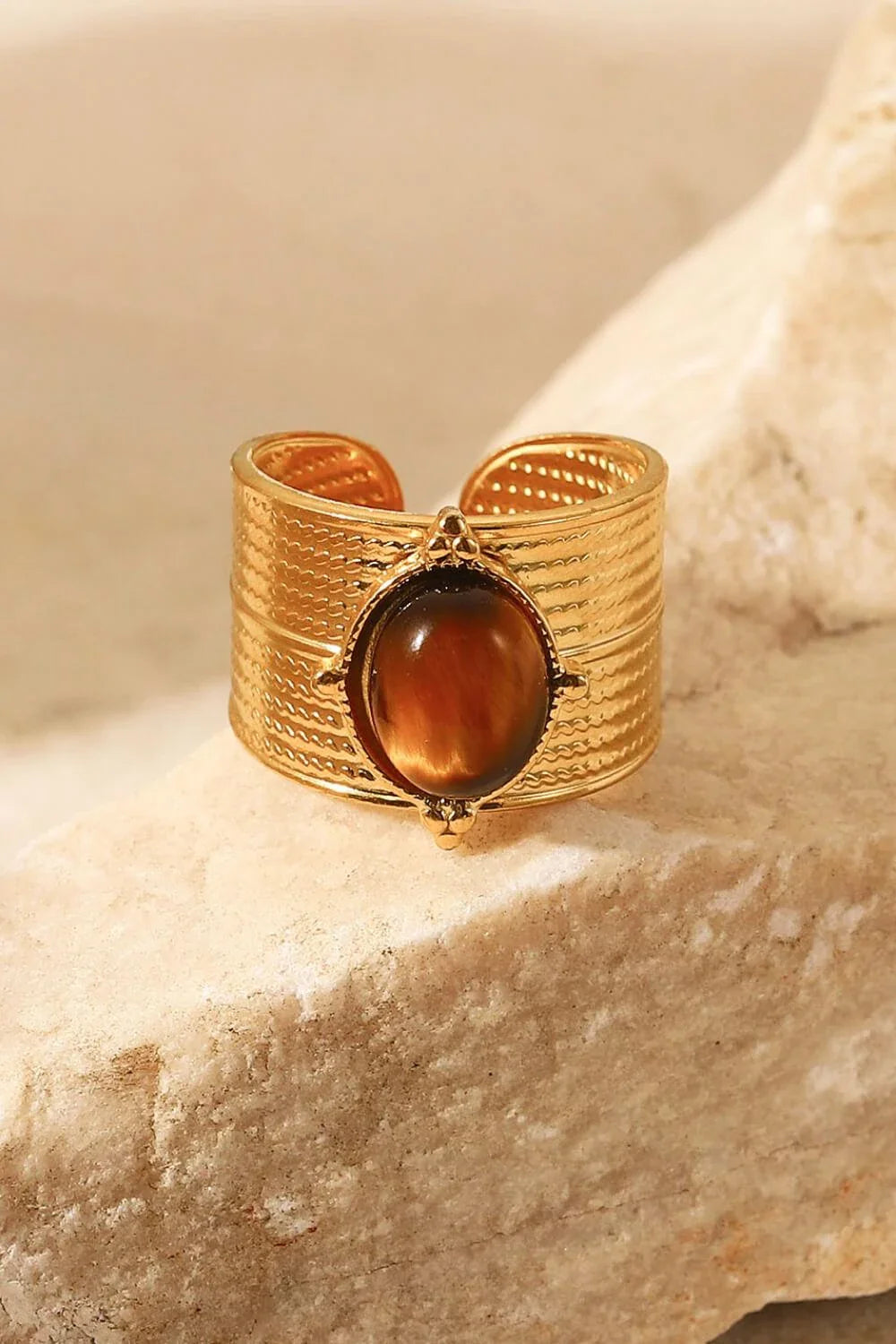 A close-up view of a polished 18K gold-plated wide-open ring, showcasing its unique and eye-catching design.