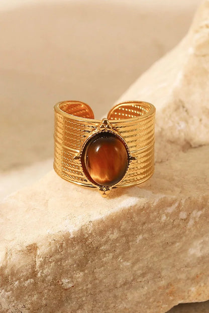 A close-up view of a polished 18K gold-plated wide-open ring, showcasing its unique and eye-catching design.
