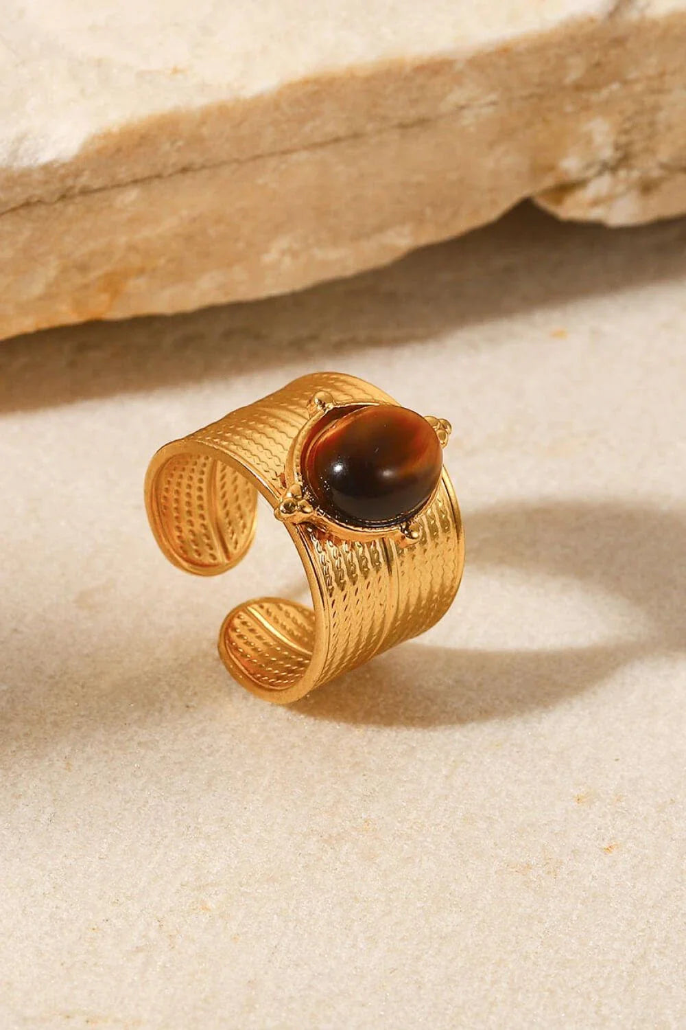 A close-up view of a polished 18K gold-plated wide-open ring, showcasing its unique and eye-catching design.