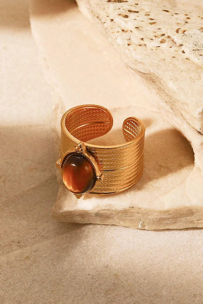 A close-up view of a polished 18K gold-plated wide-open ring, showcasing its unique and eye-catching design.
