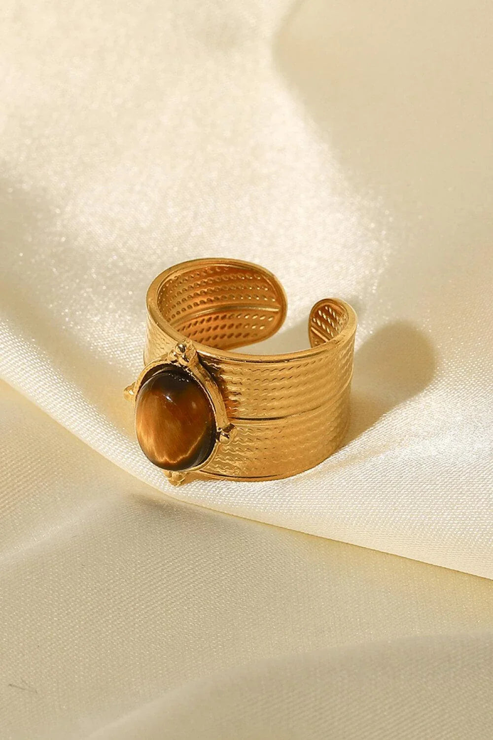 A close-up view of a polished 18K gold-plated wide-open ring, showcasing its unique and eye-catching design.