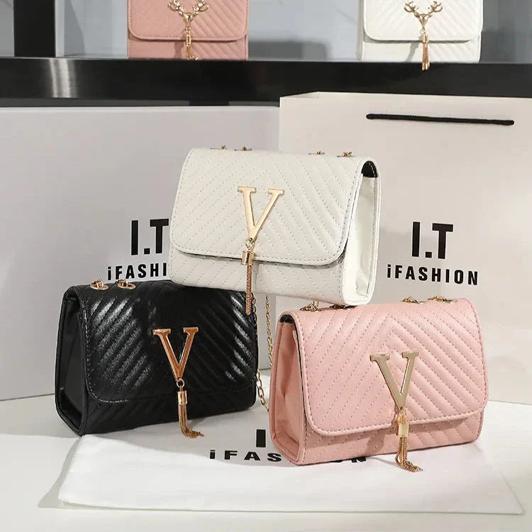 Luxury white embroidered crossbody bag with sequined tassel and elegant flap design