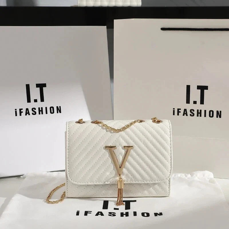 Luxury white embroidered crossbody bag with sequined tassel and elegant flap design