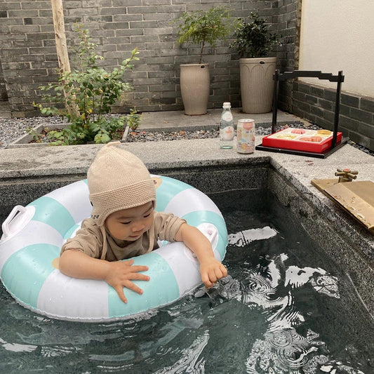 A green inflatable swim ring with a cotton pocket seat, designed for safe and enjoyable water play for children aged 1-5 years.