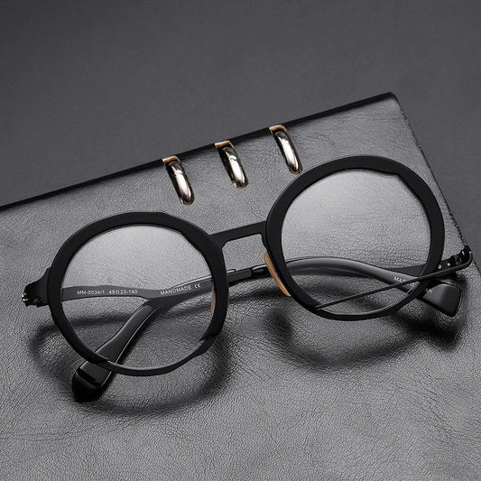 A close-up view of a premium fashion metal spectacle frame in black, white gold, and black gold colours.