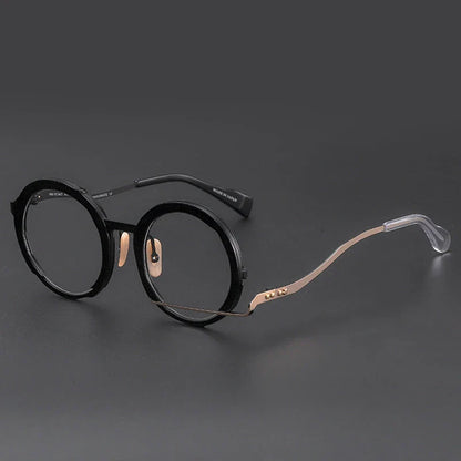 A close-up view of a premium fashion metal spectacle frame in black, white gold, and black gold colours.