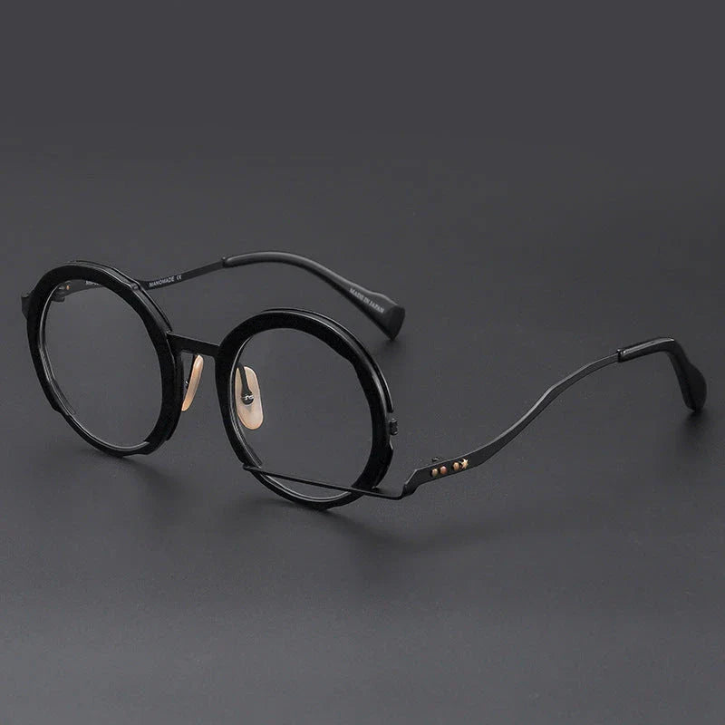 A close-up view of a premium fashion metal spectacle frame in black, white gold, and black gold colours.