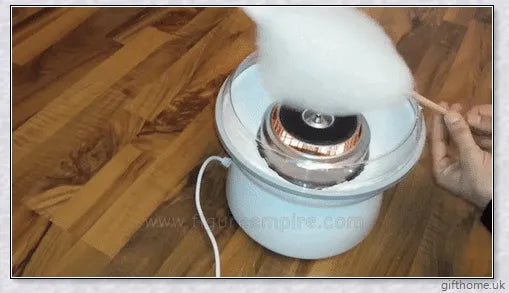 A red cotton candy maker machine on a counter, creating fluffy, cloud-like cotton candy.