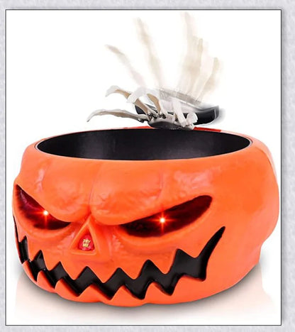 Pumpkin-shaped candy bowl with a creepy moving skeleton hand that jumps out to startle guests, ideal for Halloween decorations and parties.