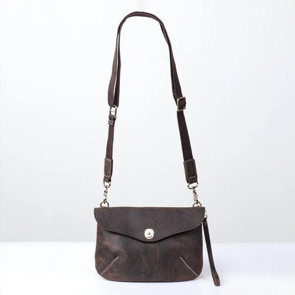 A vintage-inspired brown leather messenger bag with an adjustable strap and multiple interior compartments for organisation and storage.