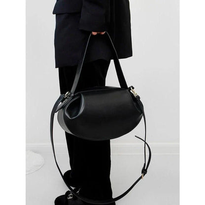Elegant round vegan leather handbag with a distinctive circular shape, durable construction, and spacious interior organisation