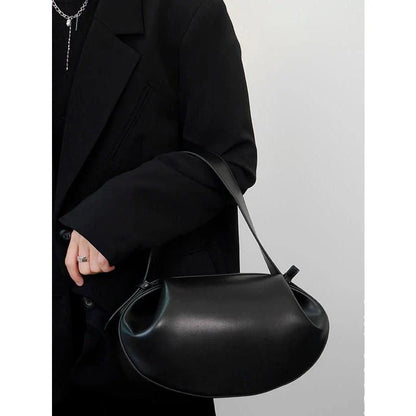 Elegant round vegan leather handbag with a distinctive circular shape, durable construction, and spacious interior organisation