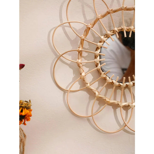 Handmade rattan decorative wall mirror with a flower-shaped design, adding natural charm and elegance to a living space.