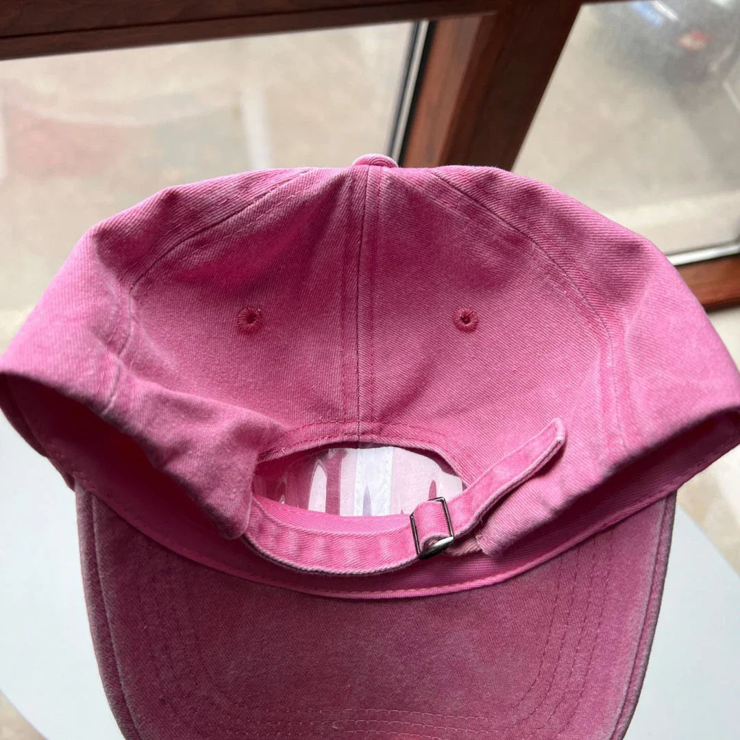 Two pink baseball caps with a cartoon love design, perfect for both women and men to add a touch of playful personality to their outfits.