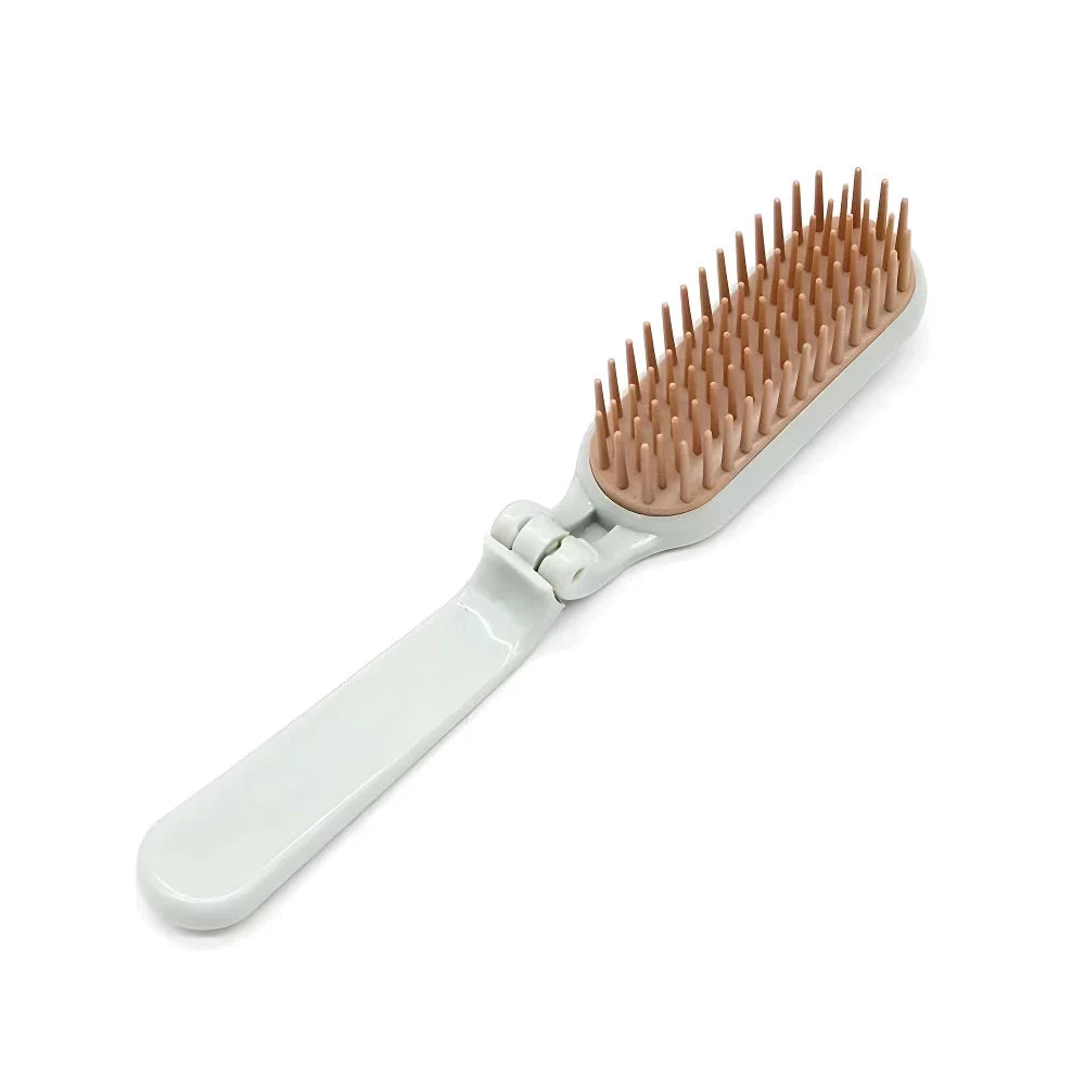 Compact, foldable hair brush with built-in scalp massager for convenient hair care on the go