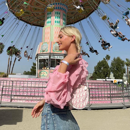 A girls' short top with a v-neck, ruffled trim, and a heart-shaped bow tie, made from stretchy chiffon fabric