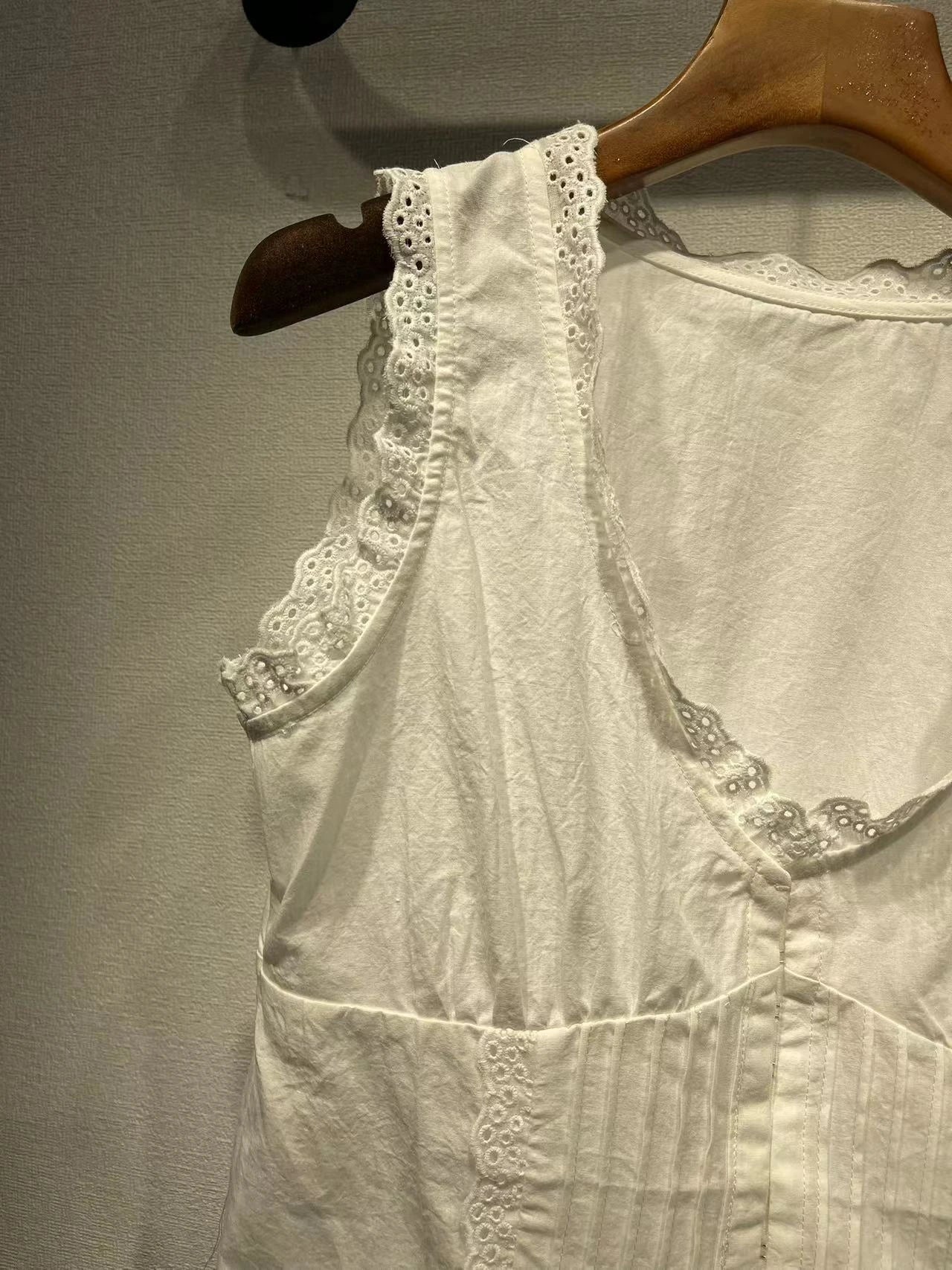Elegant white tank top with embroidered lace detailing and a sweet U-collar neckline, perfect for British-inspired casual and formal wear.