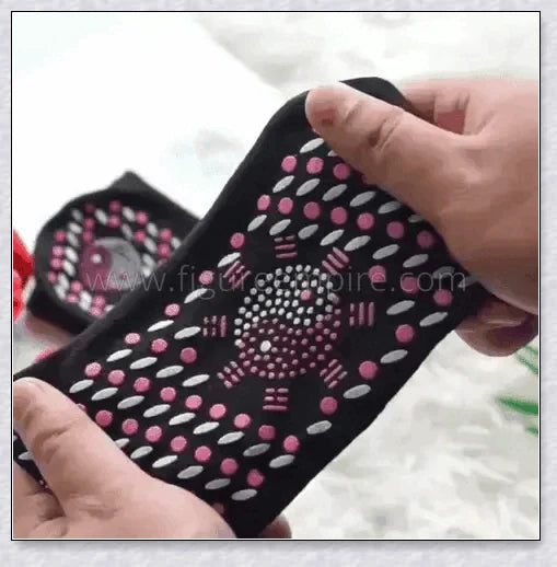 A pair of self-warming massage socks in black, red, and white colours