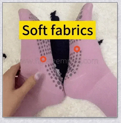 A pair of self-warming massage socks in black, red, and white colours