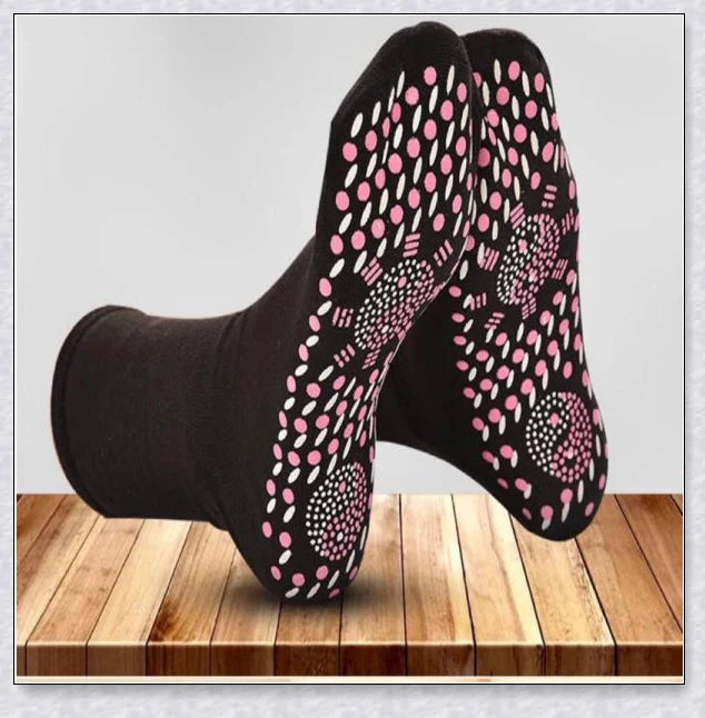 A pair of self-warming massage socks in black, red, and white colours