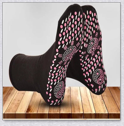 A pair of self-warming massage socks in black, red, and white colours