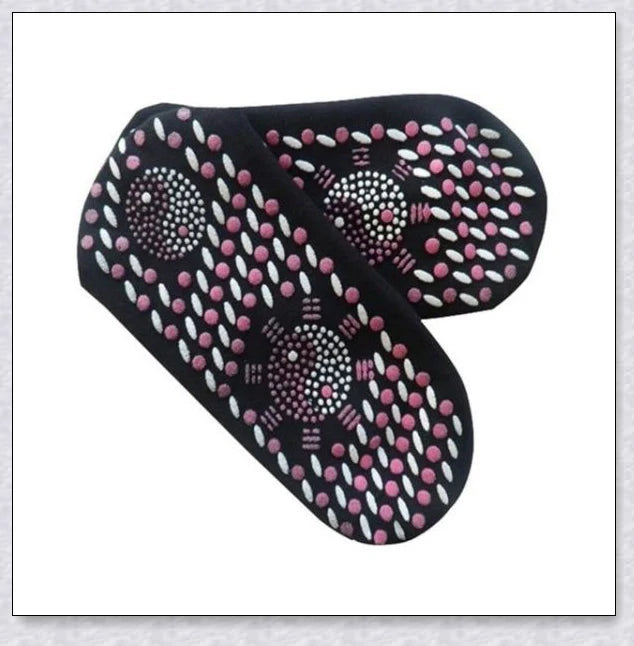 A pair of self-warming massage socks in black, red, and white colours