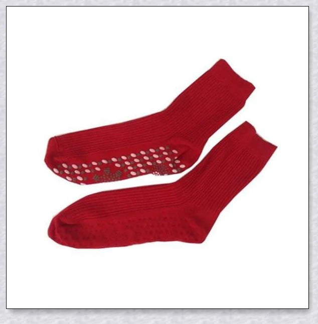 A pair of self-warming massage socks in black, red, and white colours